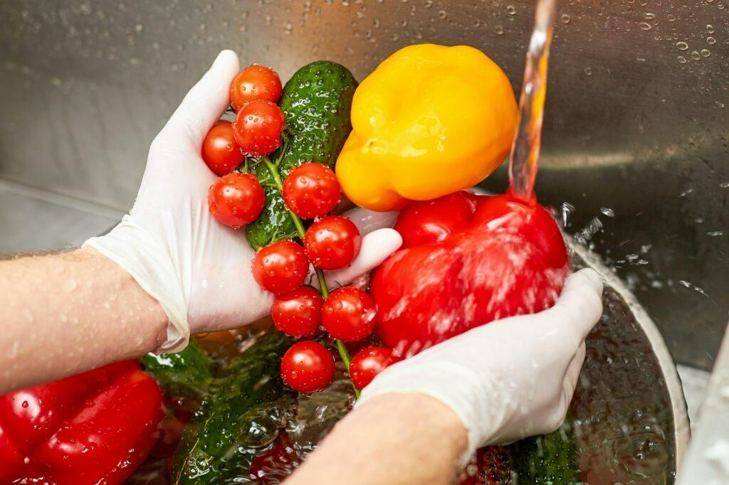 Close up washing vegetables under running tap water.