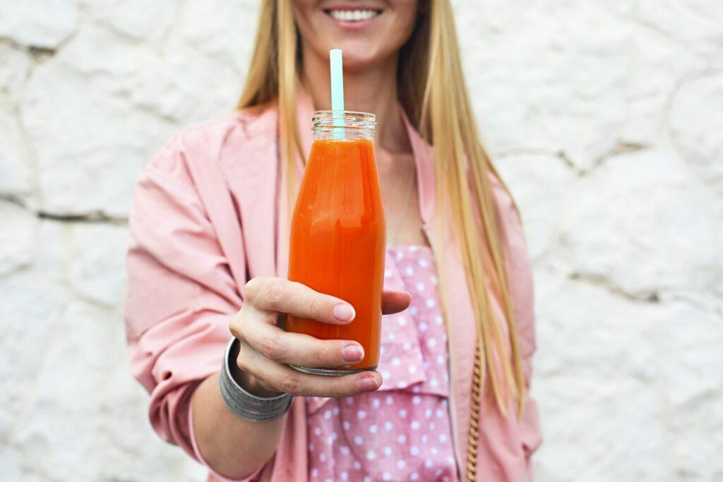 Diet nutrition with detox juice. Healthy woman posing with fresh juice bottle of detox smoothie.