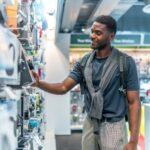 African man checking headphones in electronics store