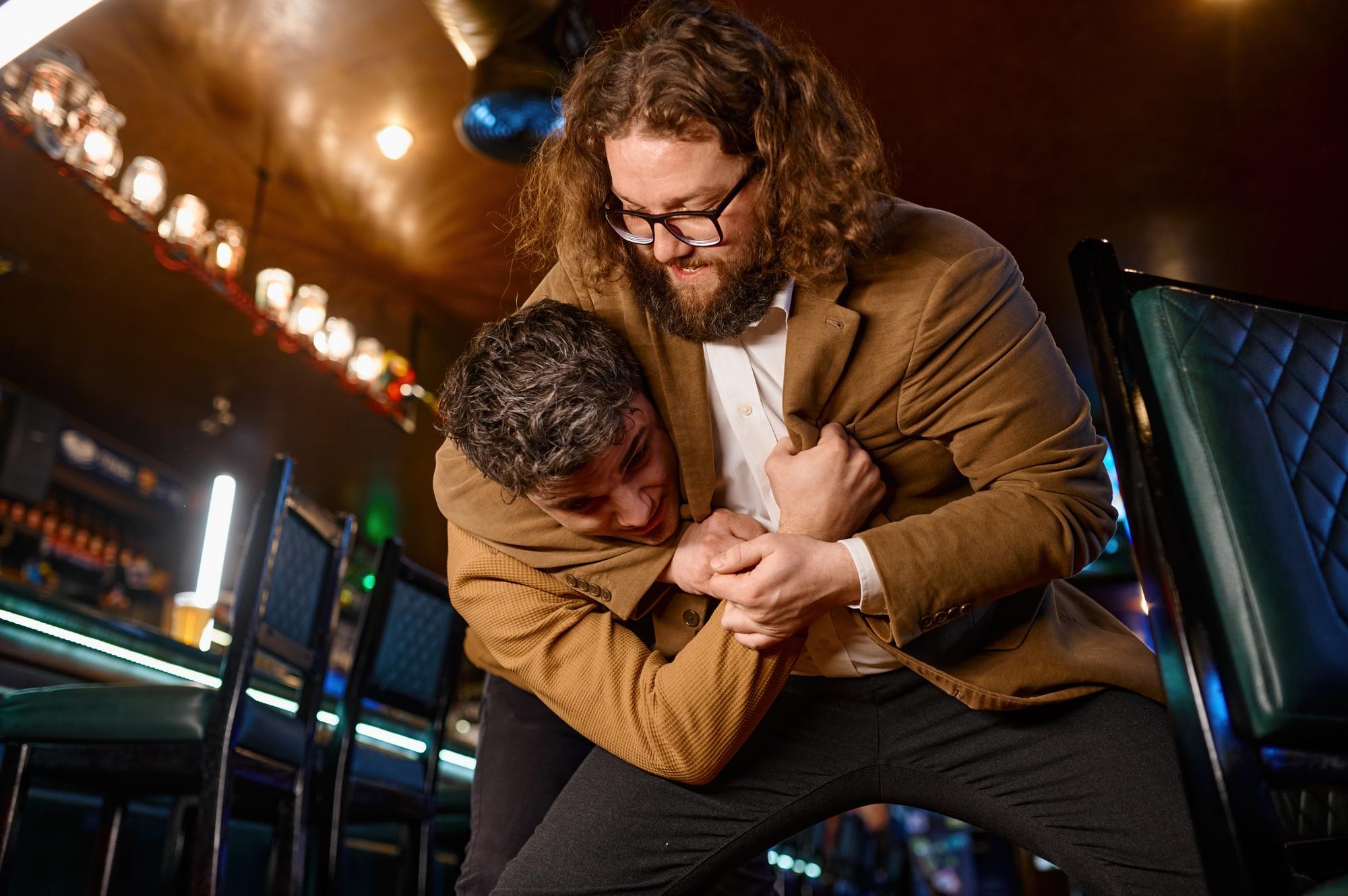 Two men fighting at sport bar for their favorite football team